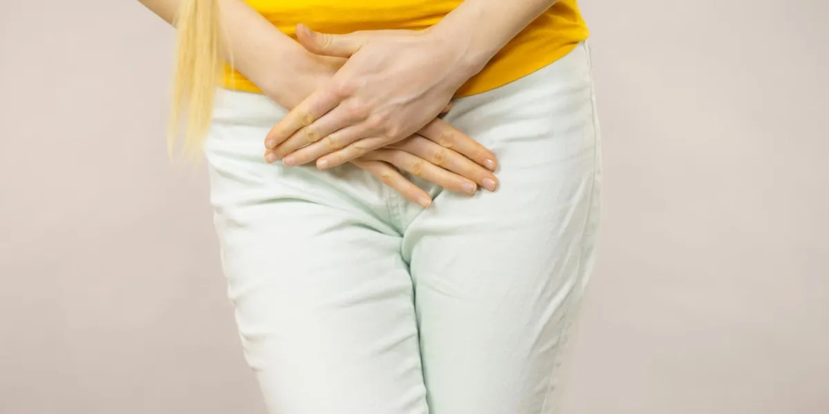 closeup, jeune, femme malade, à, mains, tenue, presser, elle, entrejambe, bas, abdomen, problèmes médicaux ou gynécologiques, concept de soins de santé