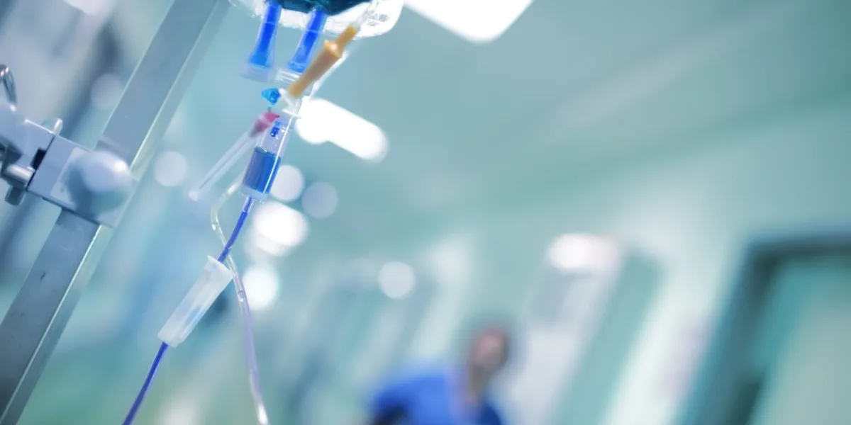 intravenous drip with blue liquid ready to use on the background of walking around medical doctor, concept of mersy killing