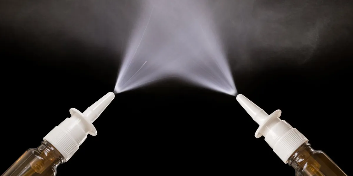 spraying nasal sprays in front of black background with copy space