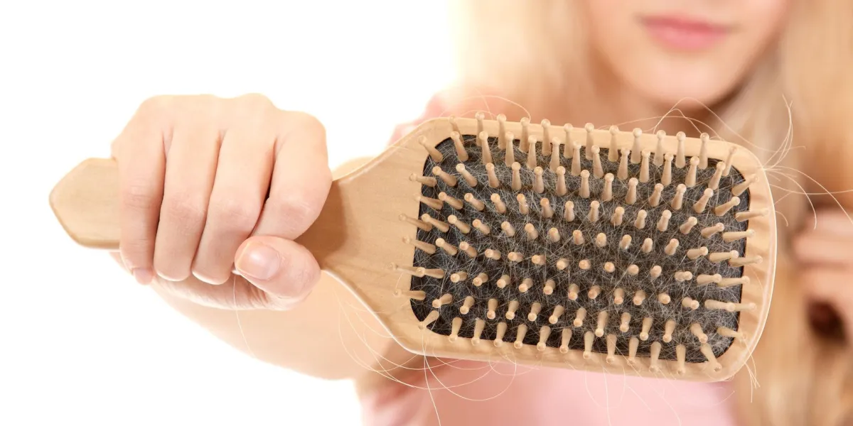 femmes avec problème de cheveux tenant le peigne de perte de cheveux dans la main, isolé sur fond blanc