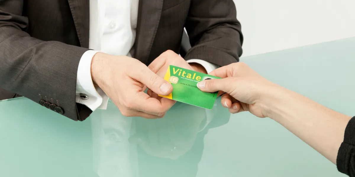 un patient donne sa carte vitale au praticien de santé