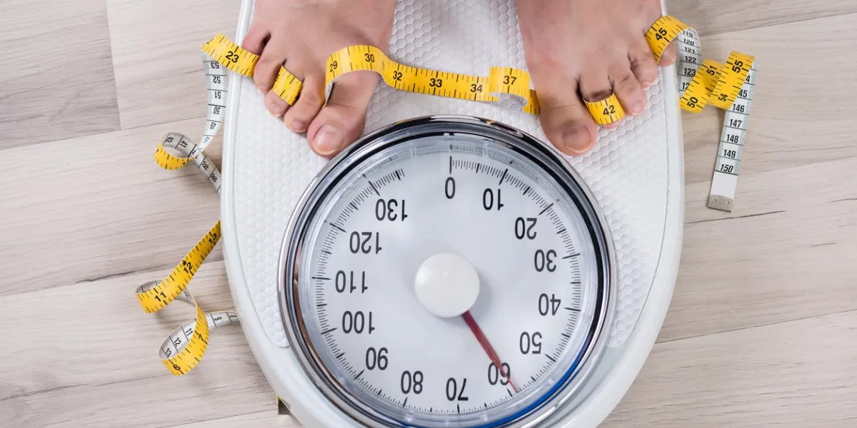 haute vue angle de la jambe de la personne avec un ruban à mesurer sur la balance