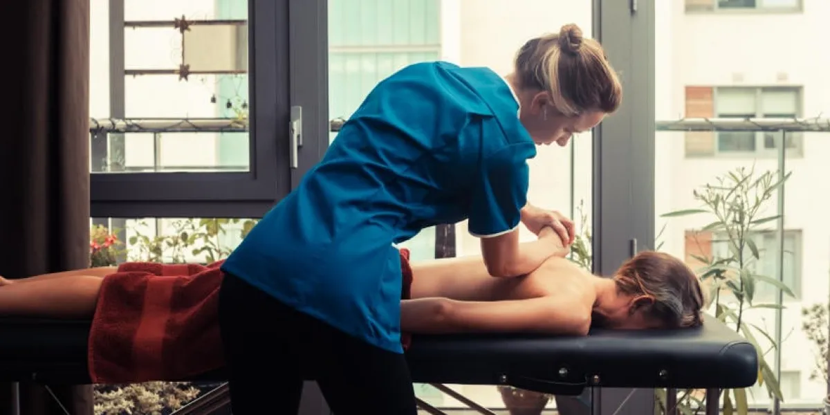 un massothérapeute traite un patient par la fenêtre