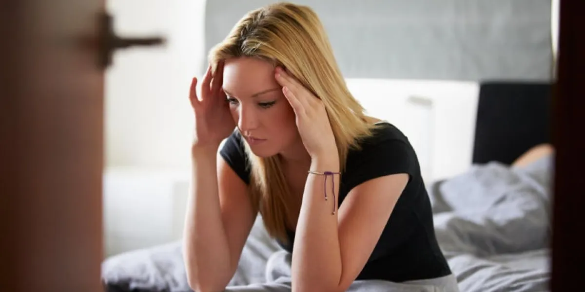 adolescente triste assis dans la chambre tandis que le petit ami dort