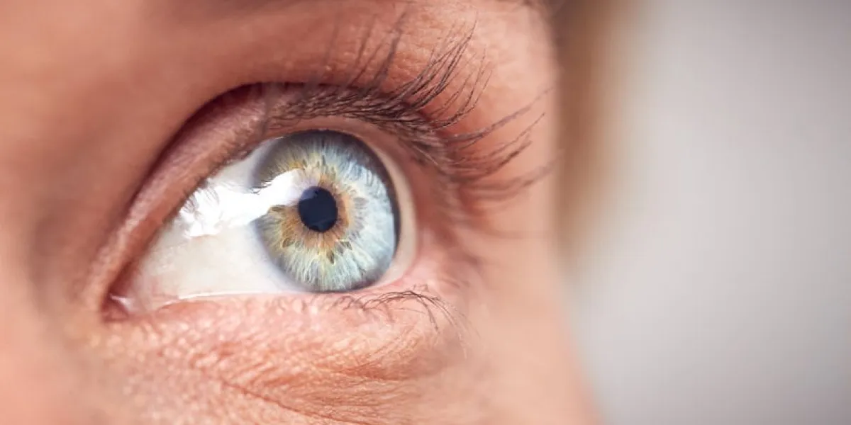 extreme close up of eye of woman against white studio background