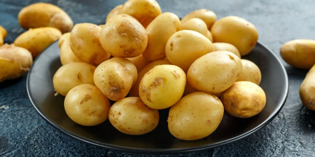 raw baby new potatoes in black plate