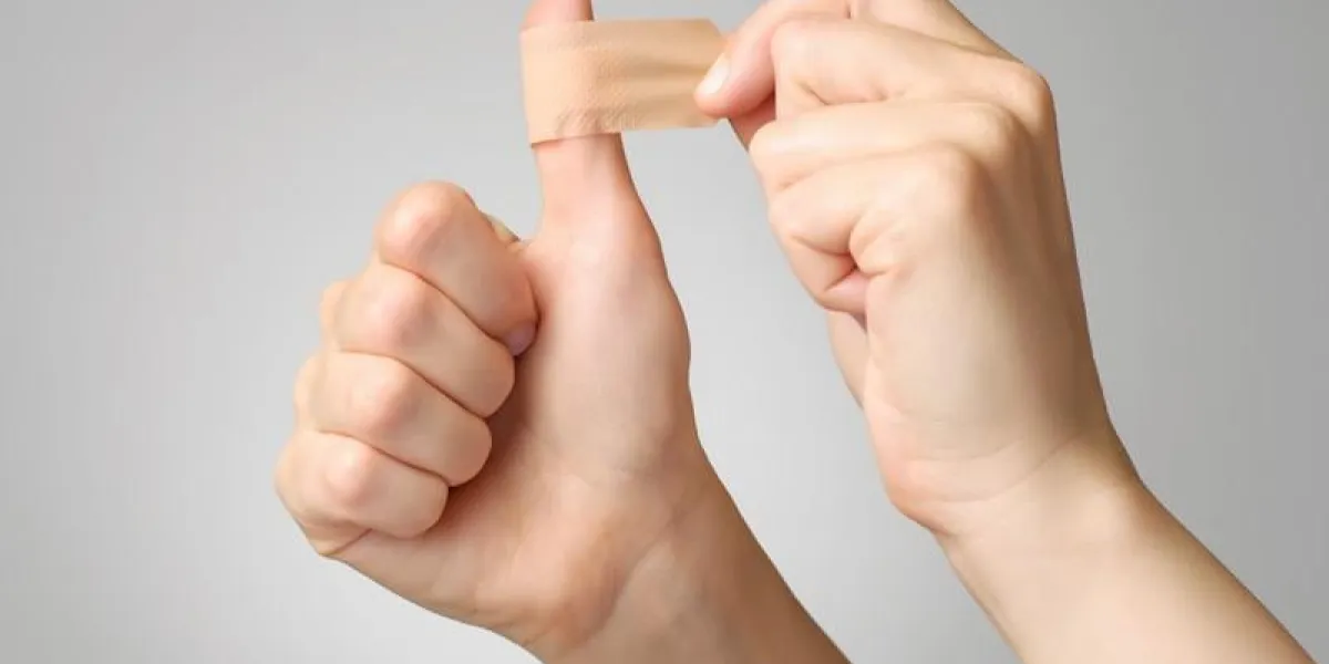 femme mettant un plâtre sur son pouce