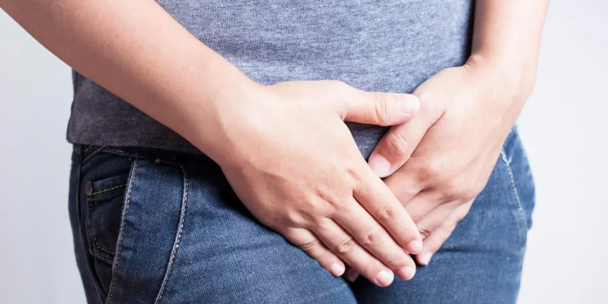 femme avec les mains tenant son entrejambe