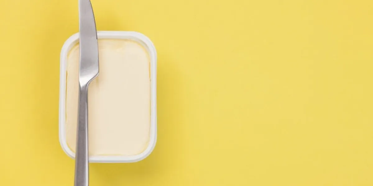 butter and knife on yellow background
