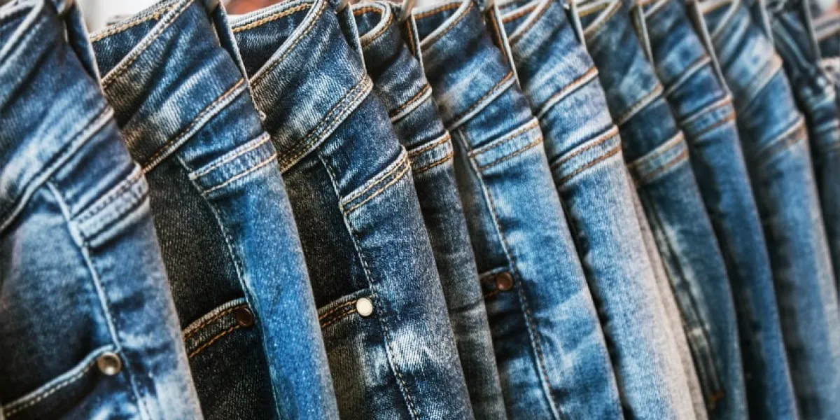 many models of jeans from different denim, texture, color hang on hangers