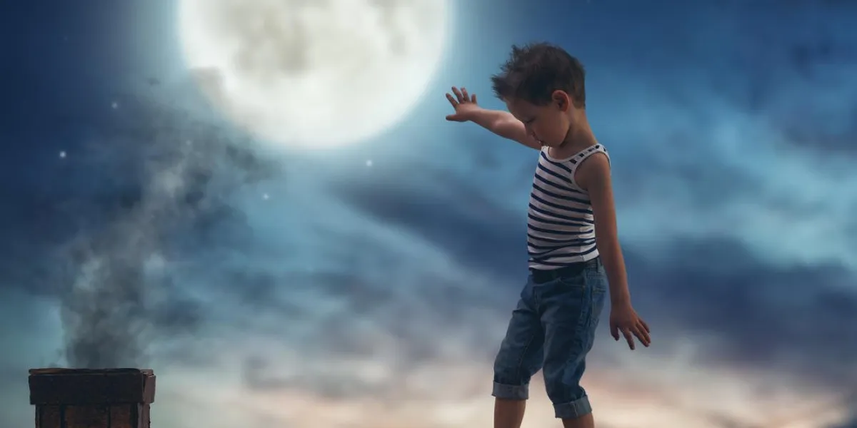 enfant garçon se promène sur le toit au clair de lune