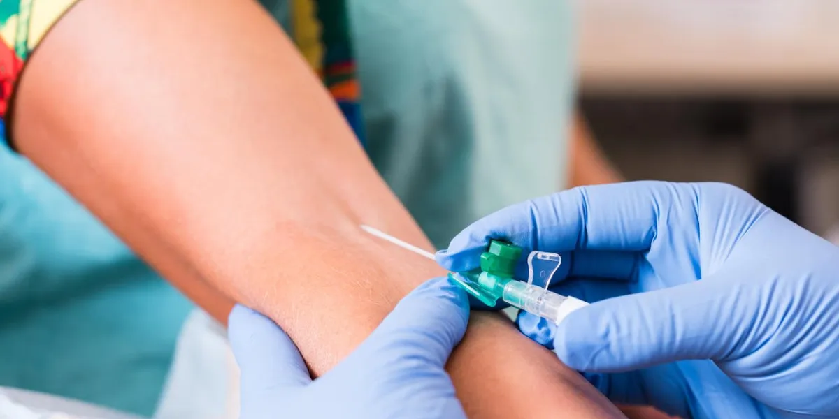 physician or nurse taking blood sample of woman