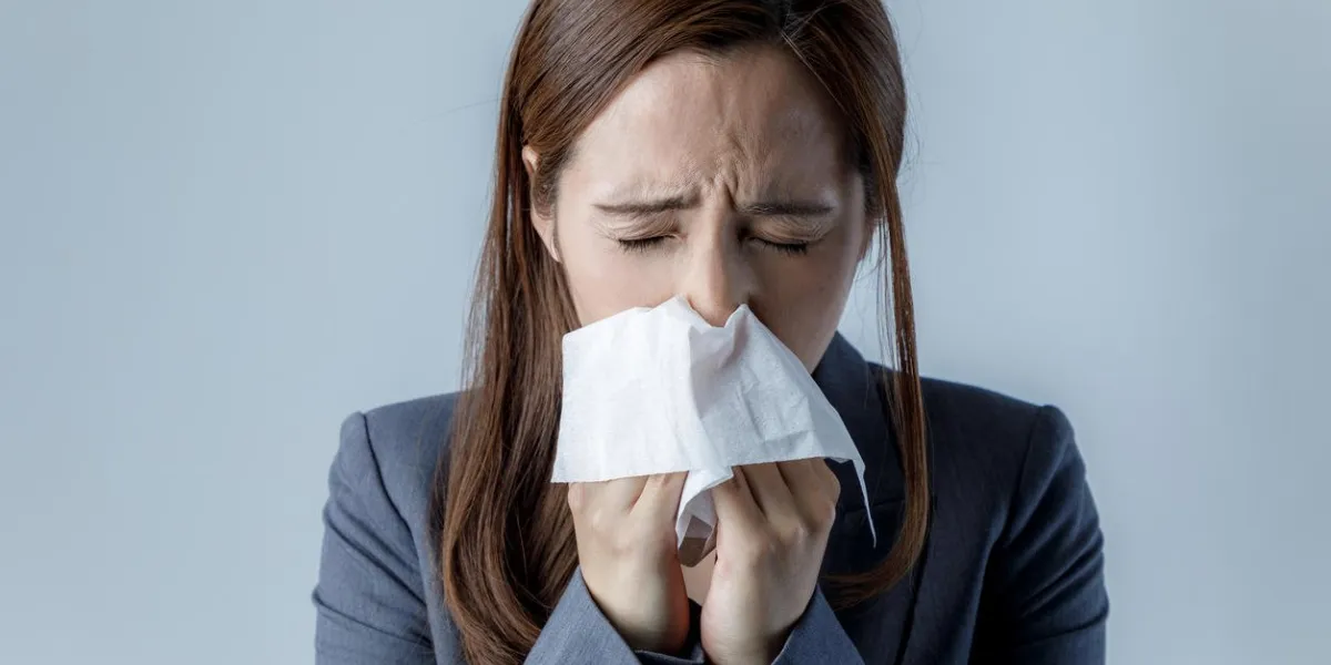 young woman blowing her nose allergic rhinitis hay fever