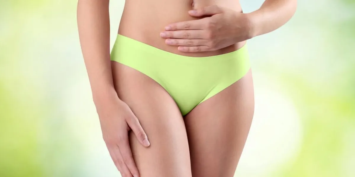 mains de la femme sur le ventre sur fond vert