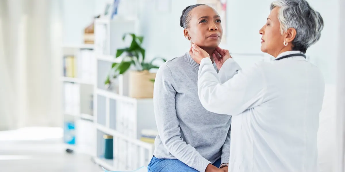 doctor, patient and feel throat in hospital of a black woman with virus, pain or infection health care worker and sick person check glands or sore neck for thyroid, tonsils or medical lymph nodes
