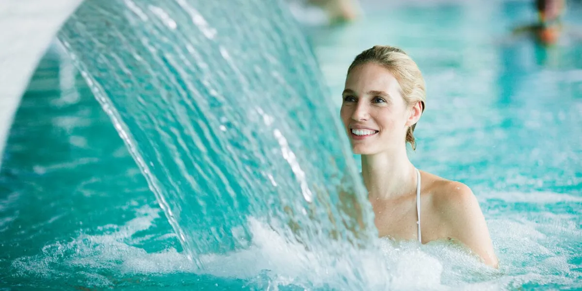 woman enjoying hydrotherapy and water stream in spa pool