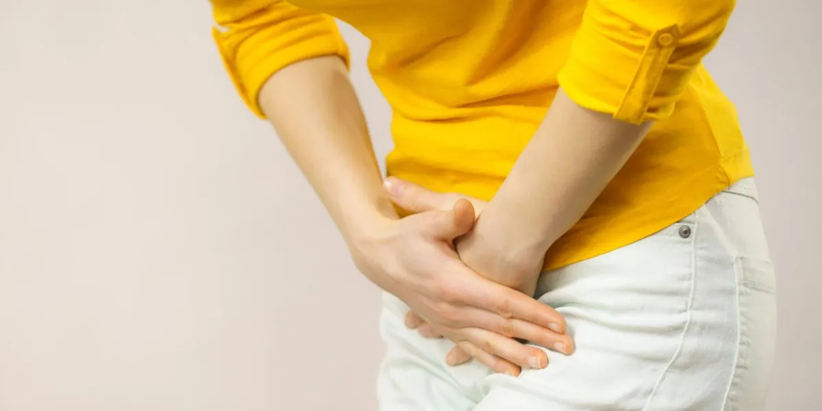 jeune femme malade avec les mains tenant pressant son entrejambe bas abdomen problèmes médicaux ou gynécologiques, concept de soins de santé