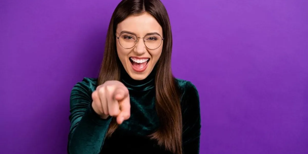 portrait of cheerful youth pointing laughing wearing eyeglasses eyewear isolated over purple violet background