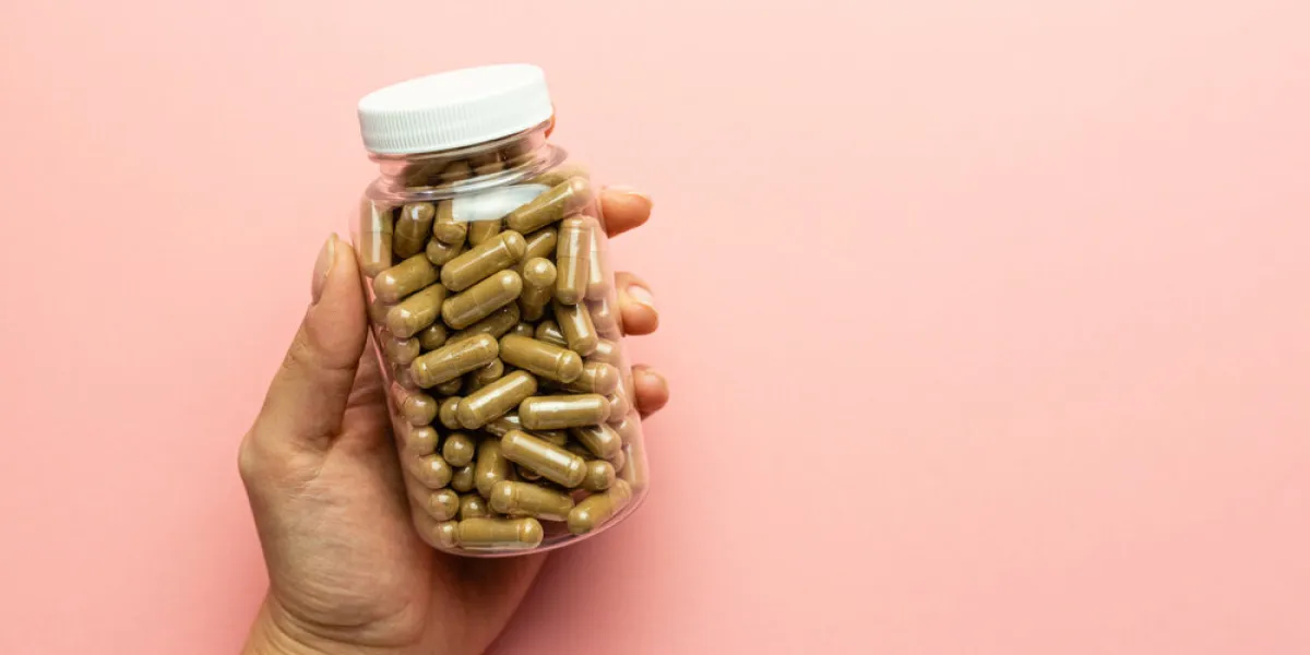 hand holding a jar with ashwagandha capsules, immunity support