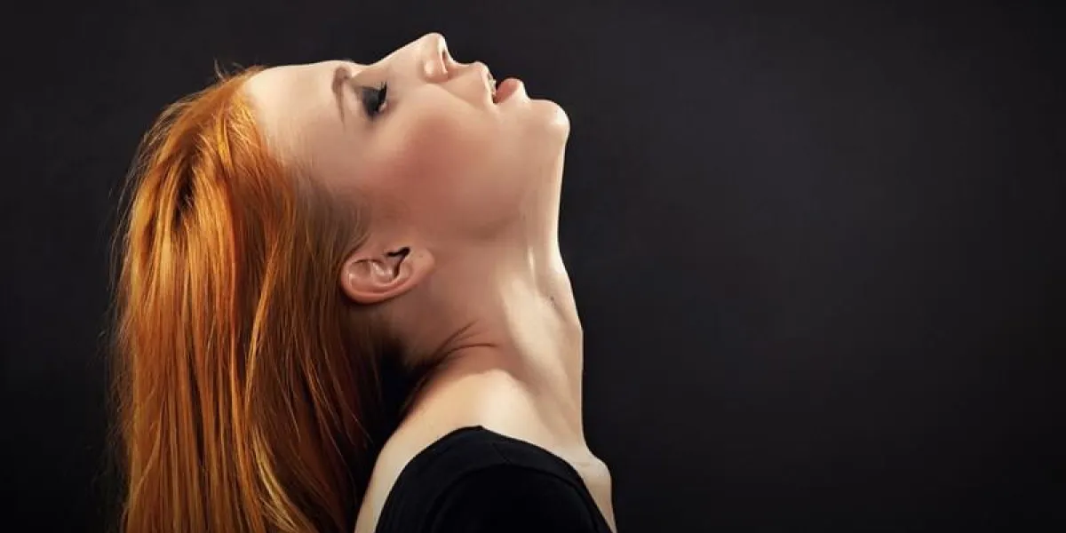 femme suscitée avec des cheveux roux sur fond noir avec copyspace