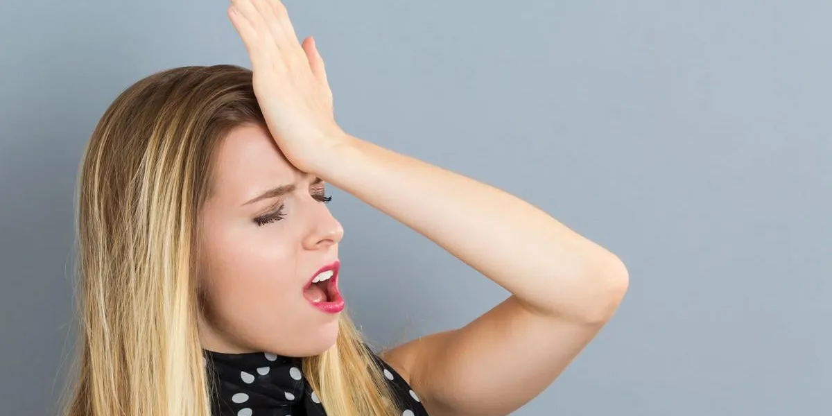 jeune femme faisant une erreur sur un fond gris