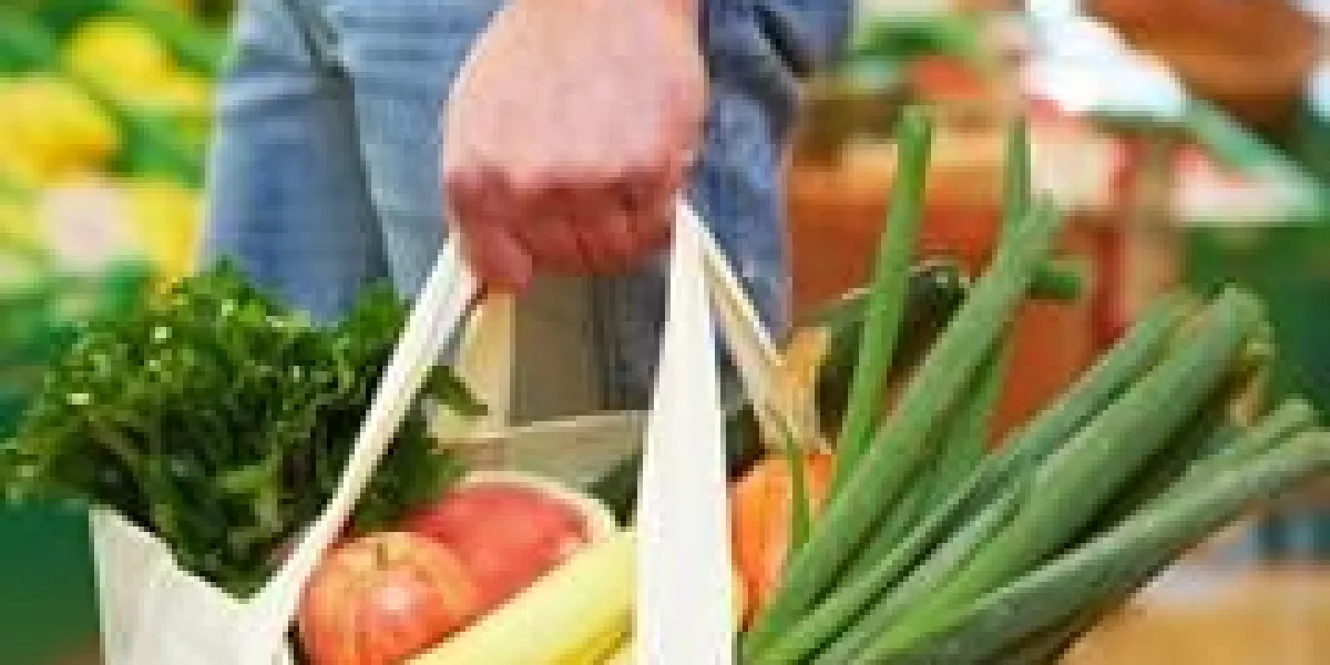 l'homme porte un sac plein avec des fruits et légumes en supermarché