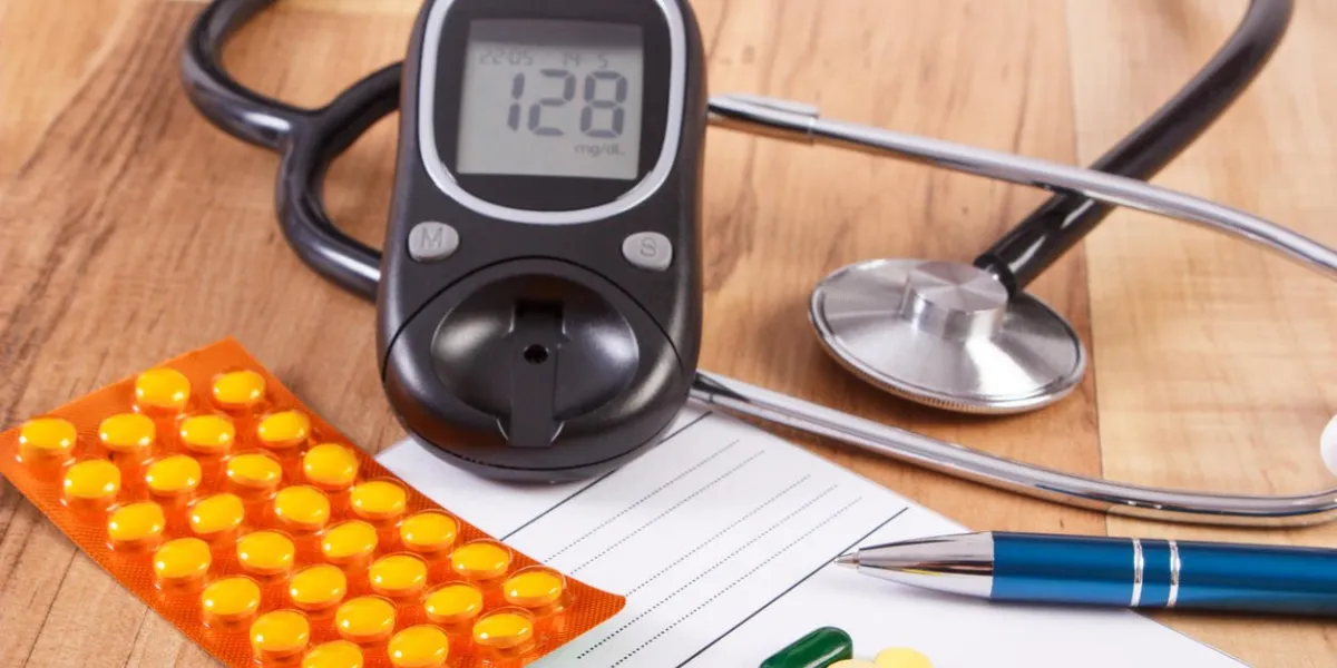 pilules médicales, des comprimés ou des suppléments pour la thérapie, la prescription, le lecteur de glycémie et le stéthoscope sur le bureau dans le bureau du médecin, le concept du diabète, le traitement et les soins de santé