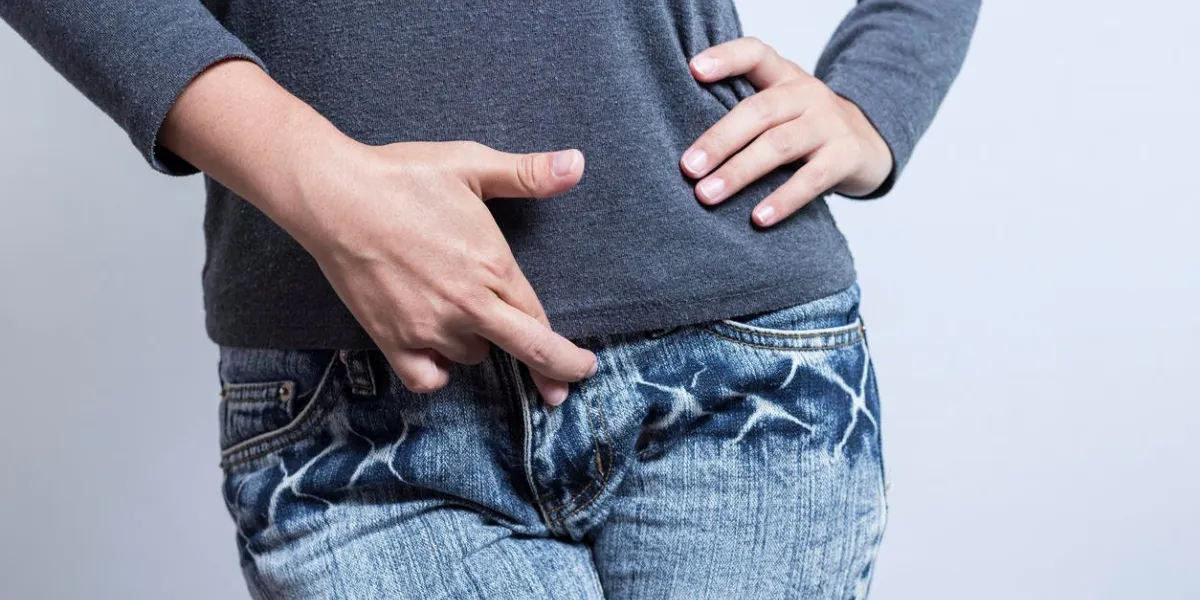 femme avec les mains tenant son entrejambe isolé sur fond blanc