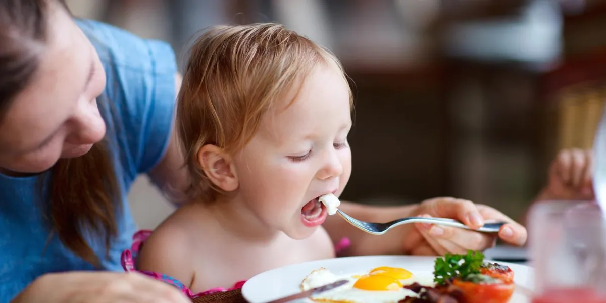 jeune mère et sa fille prenant le petit déjeuner ensemble