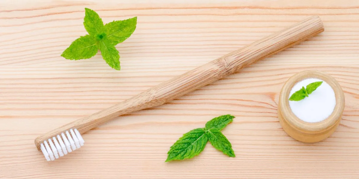 brosse à dents en bois et xylitol, soda, poudre, sel, menthe sur fond en bois
