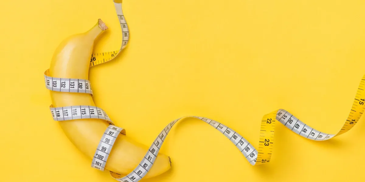 diet, fitness and health concept presented by yellow banana wrapped in measure tape isolated on yellow paper background