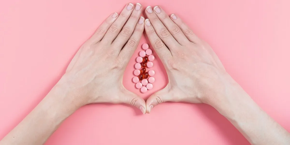 abstract image of female genital organs from hands and pills concept of women's health and the treatment of female diseases of the urinary tract