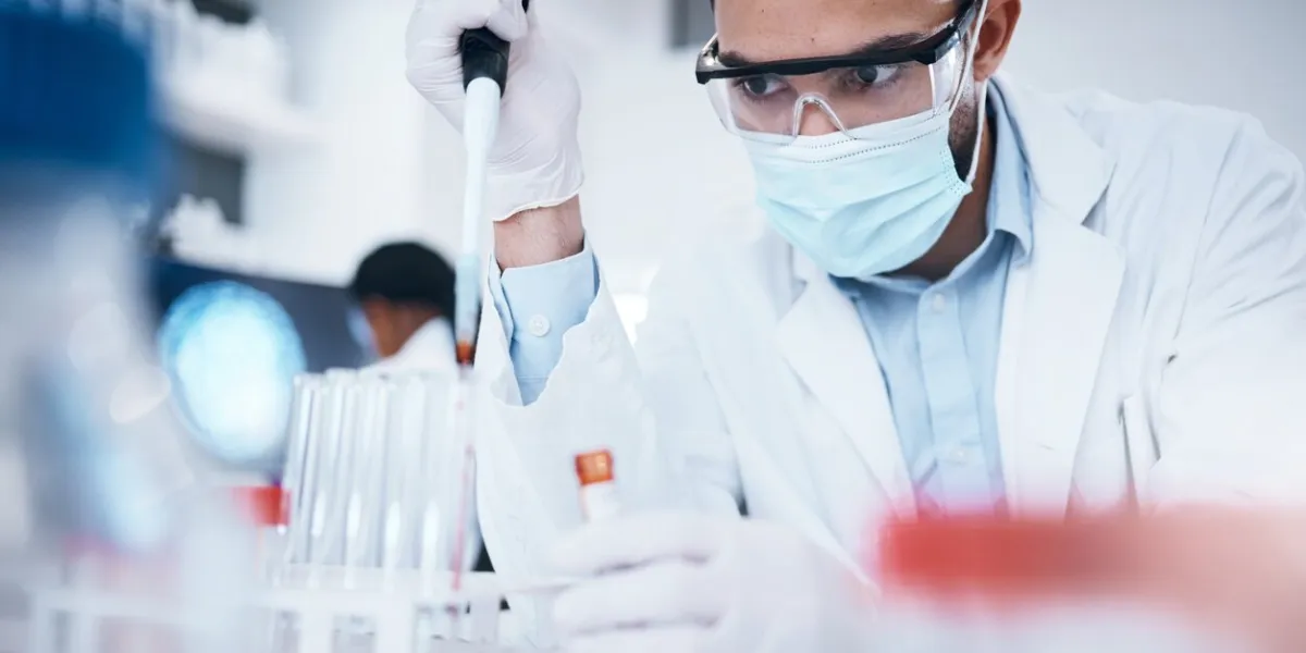 research, scientist and man with test tube, breakthrough and focus on experiment, analysis and in laboratory male researcher, employee and medical professional with chemistry, pipette or vial in lab