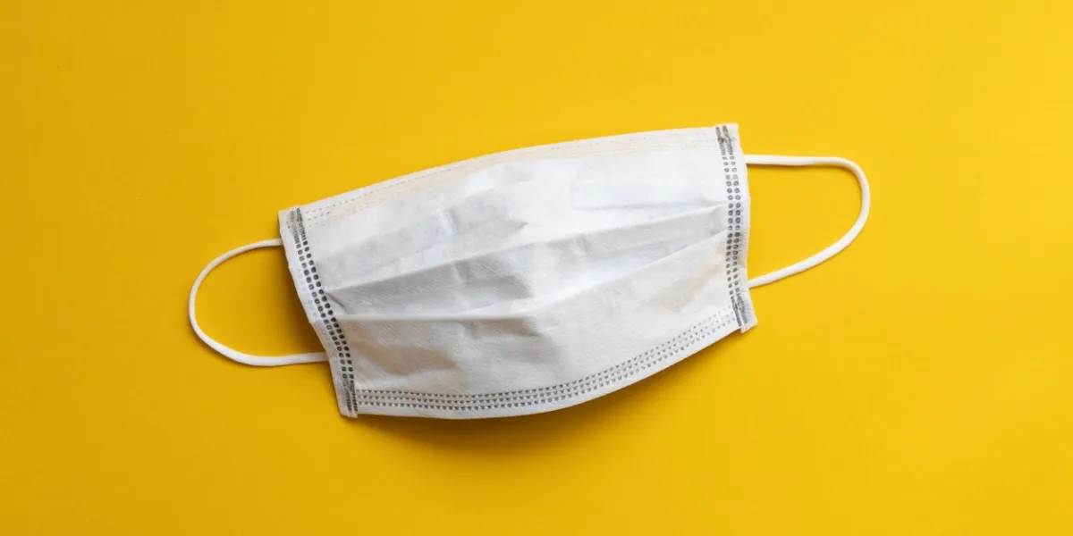 medical disposable face mask on yellow background, protection and prevention for covid-19 or wuhan novel coronavirus spread