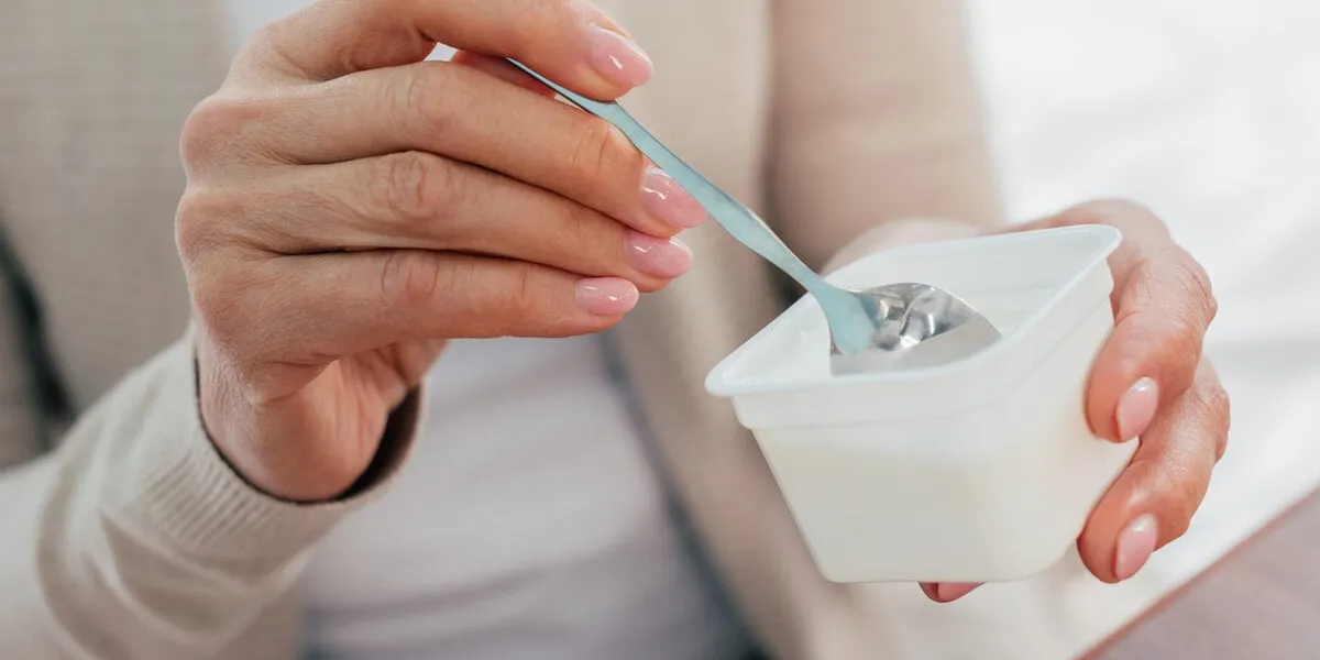 close-up partial view of senior woman eating yogurt