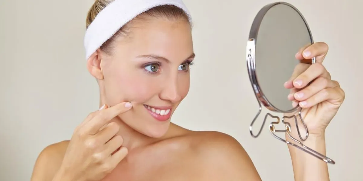 jolie femme regarde son visage souriant dans le miroir