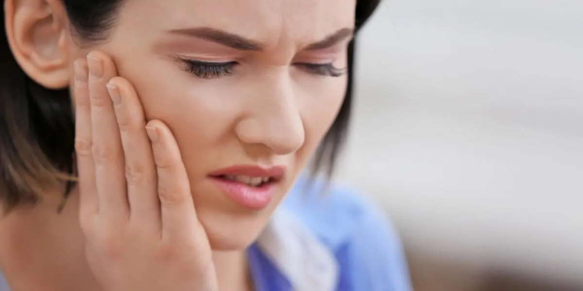 beautiful young woman suffering from toothache, close up