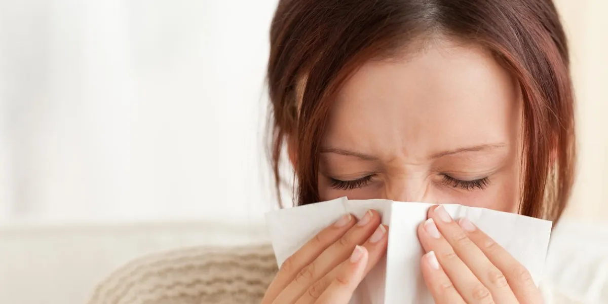 femme soufflant son nez dans un salon