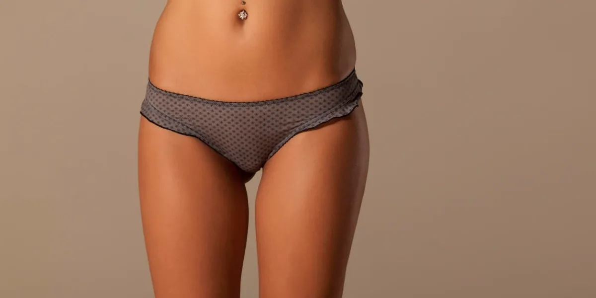 front view on female belly and hips in gray shorts