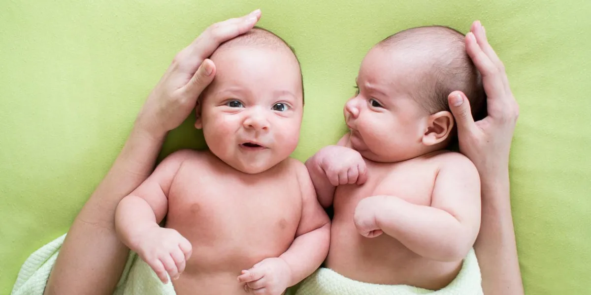 funny twins brothers babies lying on green