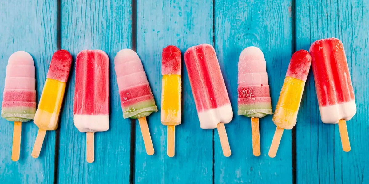 colorful fruit ice cream stick look fresh to eat placed on a blue vintage wooden floor