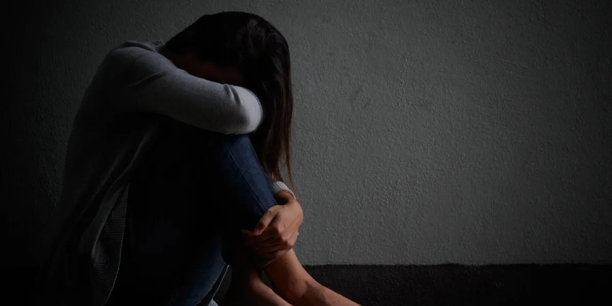 femme triste embrasser son genou et pleurer femme triste assis seul dans une chambre vide