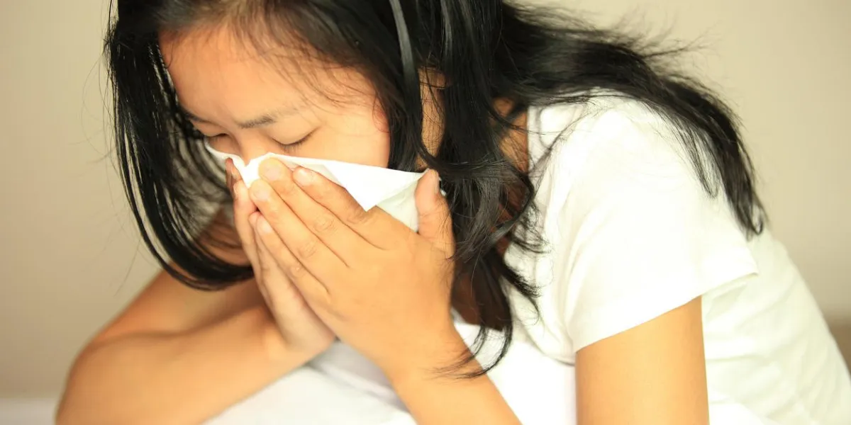cough woman sneeze with a running nose on bed