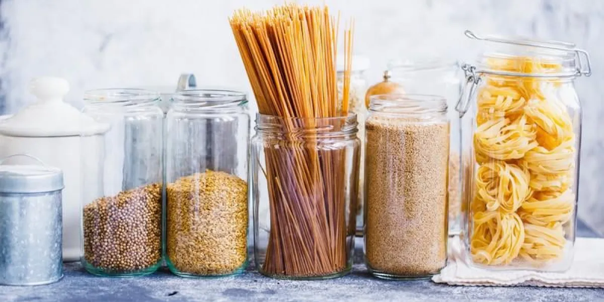 couscous, graines de lin, nouilles, quinoa, pâtes linguine en pots de verre sur la table de cuisine gris
