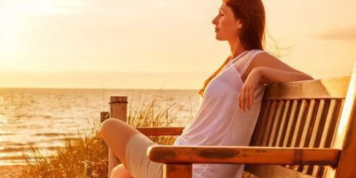 femme relaxante sur la côte du coucher du soleil