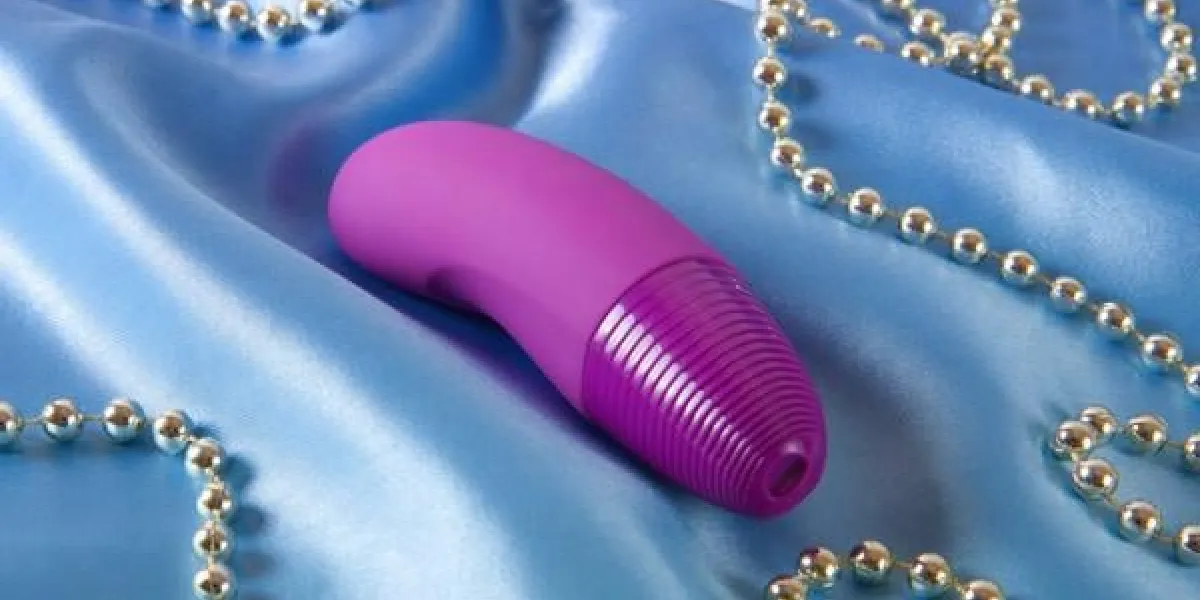 sex toy pour femme - vibrateur violet sur fond bleu satin