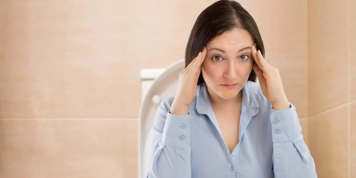 femme d'affaires dans les toilettes avec des problèmes de constipation