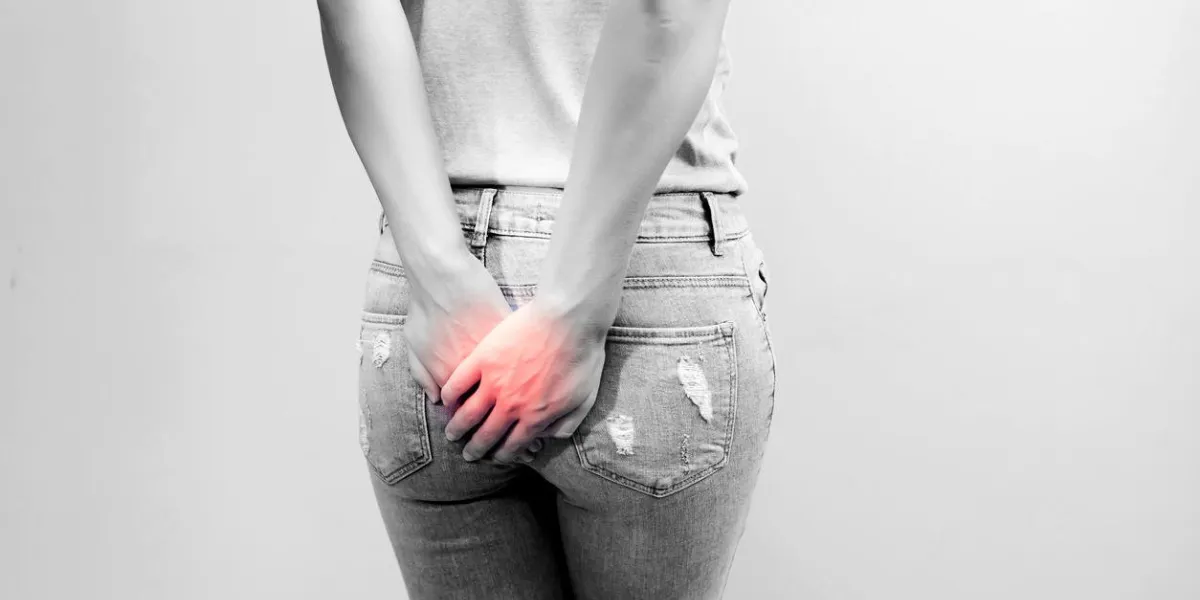woman hand holding her bottom because having abdominal pain and hemorrhoids, health care concept