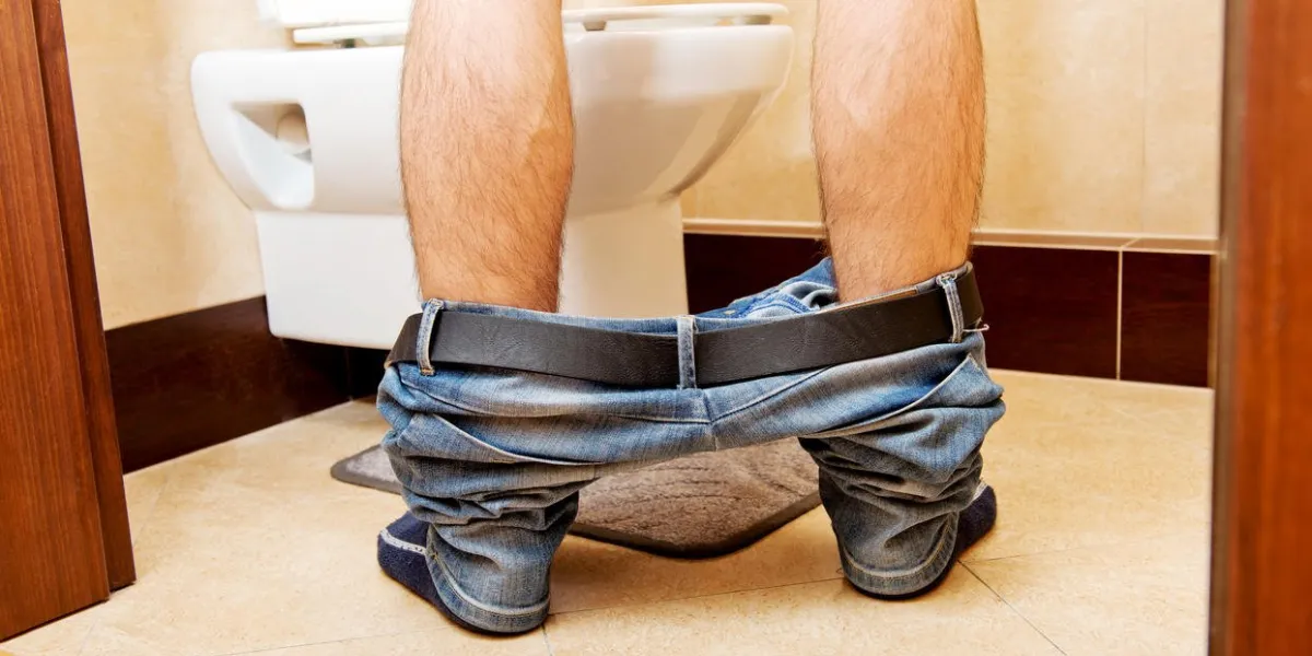 man peeing in toilet at home