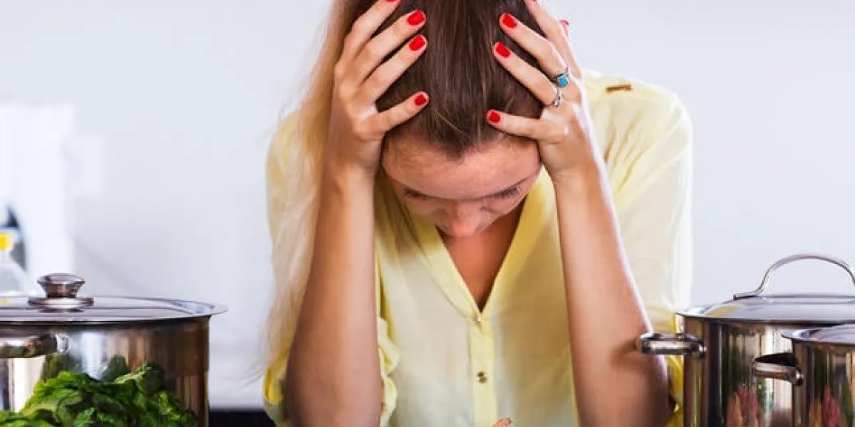 femme au foyer fatiguée avec de la viande et des légumes à la table de la cuisine